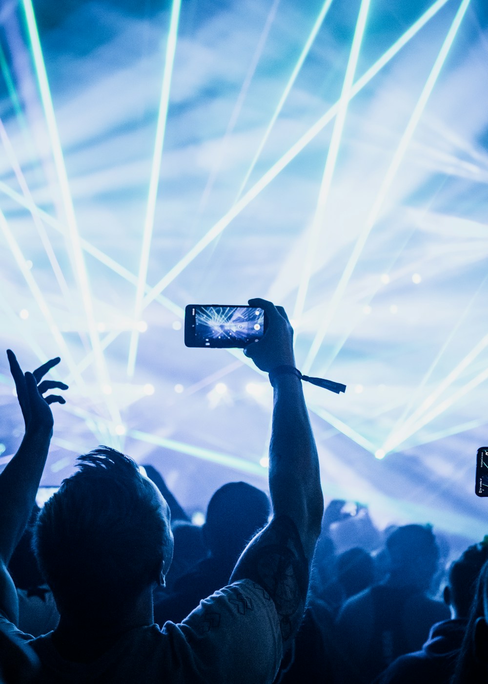 Un fan registra el concierto con su teléfono entre luces y láseres azules